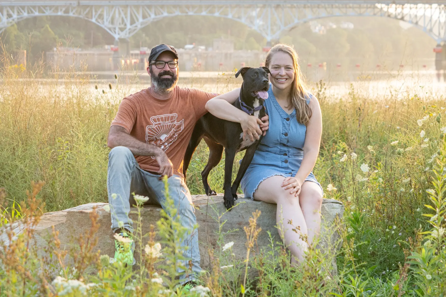 A couple with their dog in a sunlit field