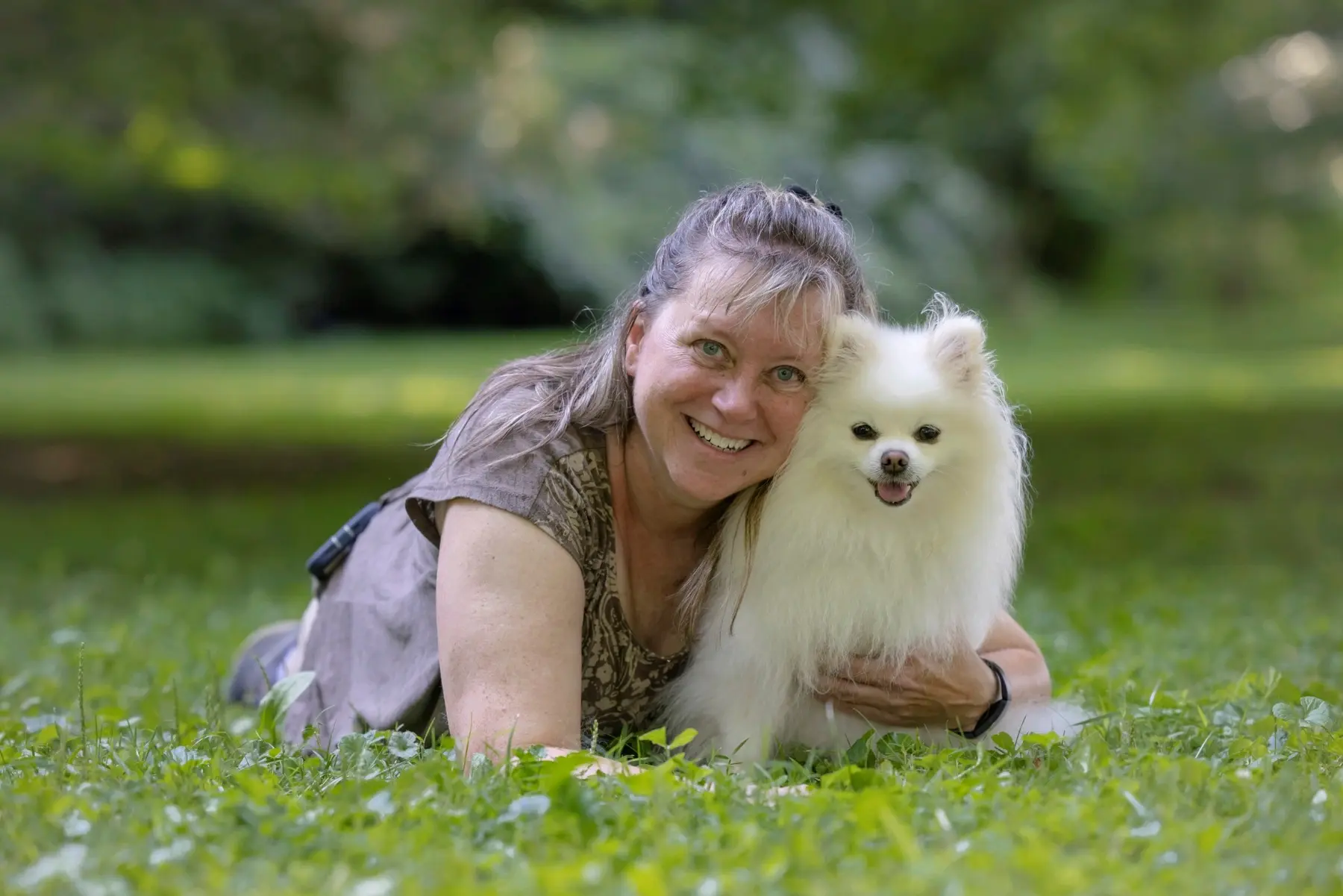 Elaine lying in the grass beside her dog Simba