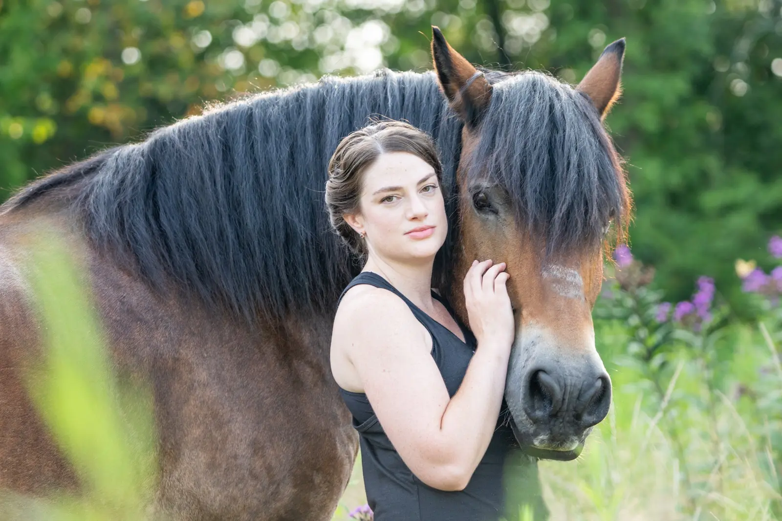 Woman sharing a quiet moment with a dark horse