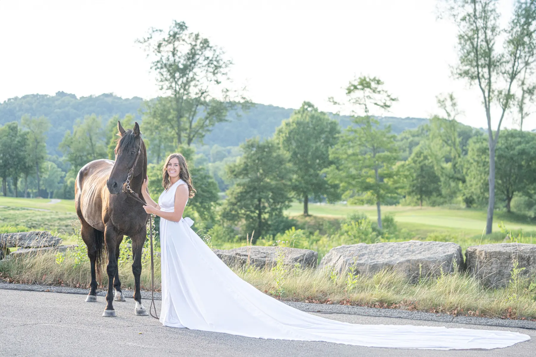 A woman standing beside her horse in a scenic landscape